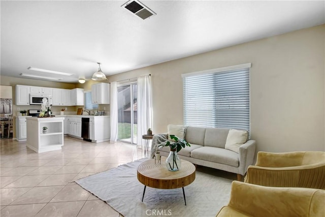 living area with visible vents and light tile patterned flooring