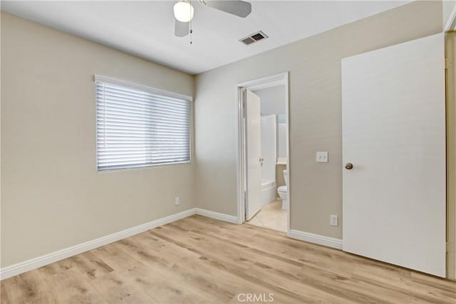 unfurnished bedroom with ceiling fan, visible vents, baseboards, connected bathroom, and light wood-style flooring