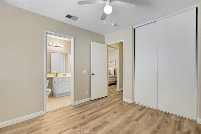 unfurnished bedroom with visible vents, baseboards, a closet, connected bathroom, and light wood-style floors