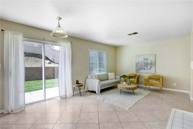living room with baseboards, visible vents, and light tile patterned floors