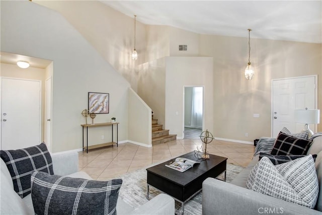 tiled living area with stairway, high vaulted ceiling, baseboards, and visible vents
