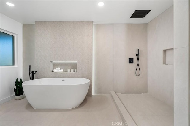 full bath with a walk in shower, a freestanding bath, and recessed lighting
