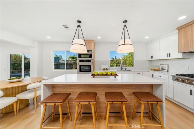 24705 Queens Ct, Laguna Niguel, CA 92677 - kitchen featuring stainless steel appliances, a sink, a breakfast bar area, light wood-style floors, and recessed lighting