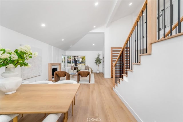 dining space with stairs, wood finished floors, baseboards, high vaulted ceiling, and recessed lighting