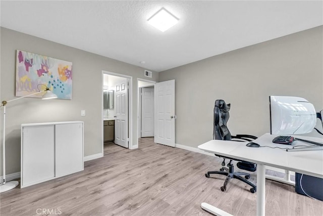office with baseboards, visible vents, and light wood-style floors