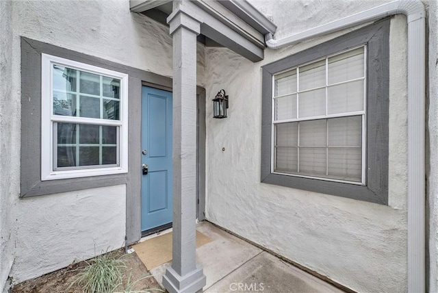 property entrance with stucco siding