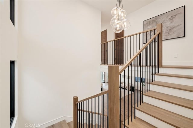 932 9th St, Manhattan Beach, CA 90266 - staircase with a chandelier, wood finished floors, and baseboards