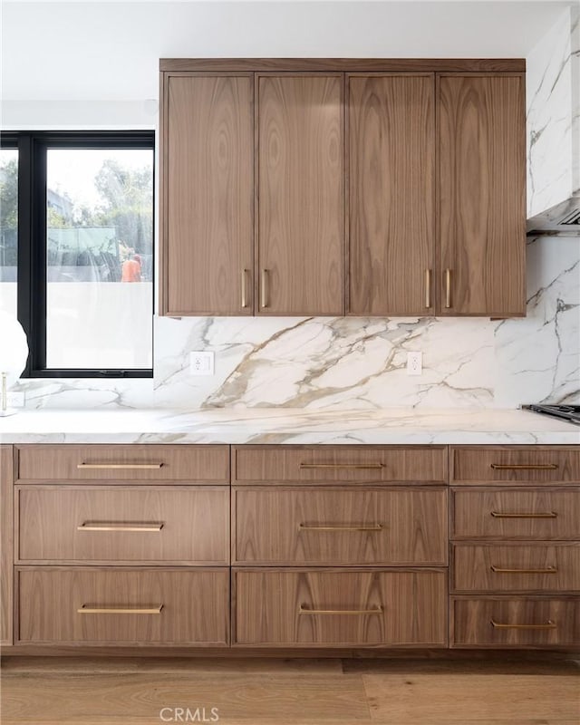 932 9th St, Manhattan Beach, CA 90266 - kitchen with decorative backsplash, light stone counters, ventilation hood, light wood-style floors, and modern cabinets