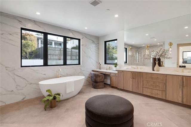 932 9th St, Manhattan Beach, CA 90266 - bathroom with a freestanding tub, recessed lighting, double vanity, and tile walls