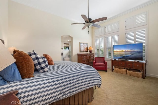bedroom with ceiling fan, carpet floors, arched walkways, baseboards, and ornamental molding