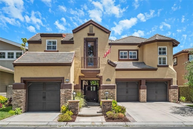view of front of property with stucco siding, driveway, stone siding, and a garage