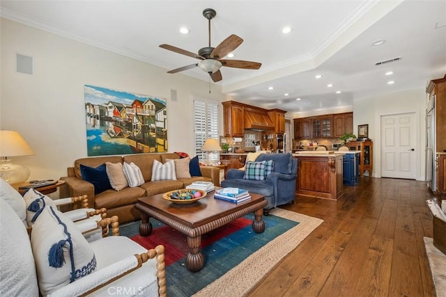 living room with a ceiling fan, recessed lighting, dark wood-type flooring, visible vents, and ornamental molding