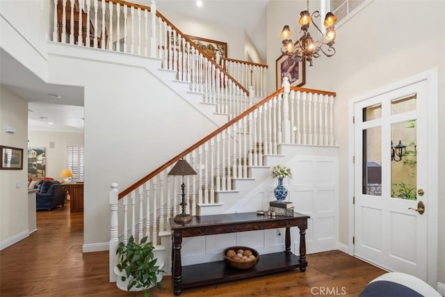 entryway featuring stairway, baseboards, a high ceiling, and wood-type flooring