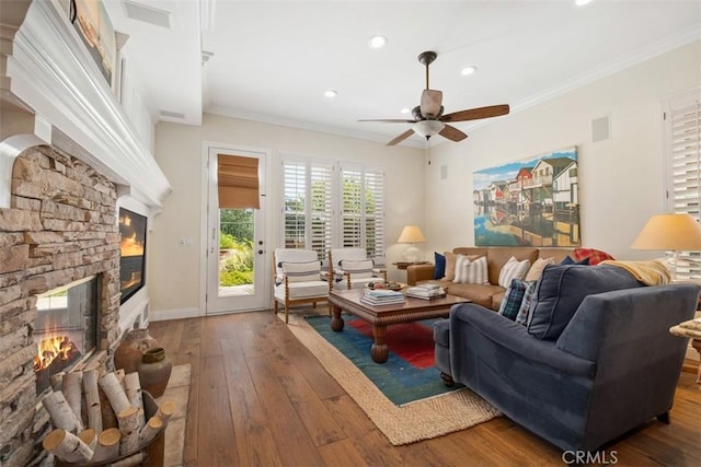 living area featuring wood-type flooring, a ceiling fan, recessed lighting, and a stone fireplace
