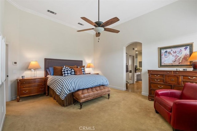bedroom with crown molding, light carpet, arched walkways, baseboards, and visible vents
