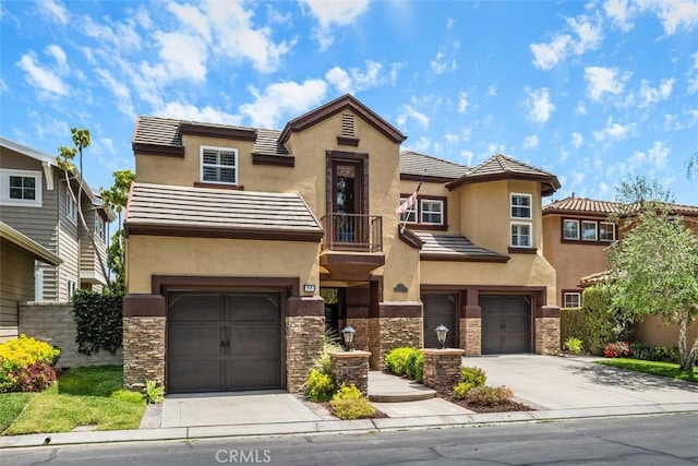 view of front of house featuring a garage, stucco siding, driveway, and stone siding