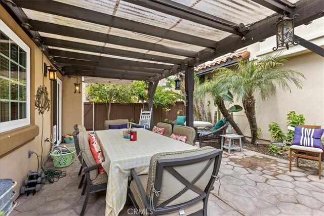 view of patio / terrace featuring fence, a pergola, and outdoor dining space
