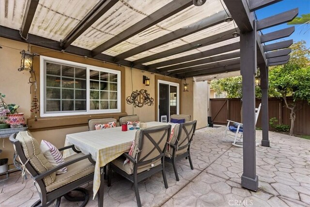 view of patio featuring fence, a pergola, and outdoor dining area
