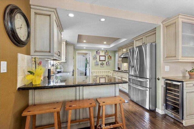 kitchen featuring cream cabinets, beverage cooler, dark wood finished floors, a peninsula, and stainless steel refrigerator with ice dispenser