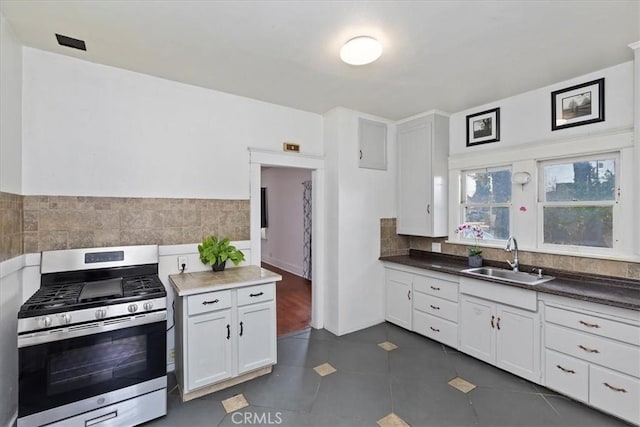 4643 Victoria Ave, Riverside, CA 92507 - kitchen with white cabinets, a sink, stainless steel gas range oven, decorative backsplash, and dark tile patterned flooring