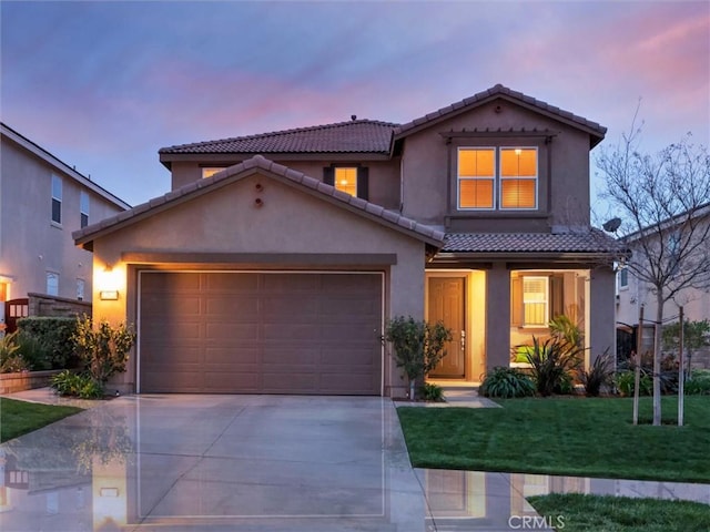 view of front of home featuring a front yard, stucco siding, a tiled roof, an attached garage, and driveway