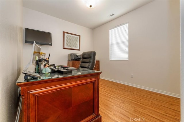home office featuring light wood-type flooring, baseboards, and visible vents