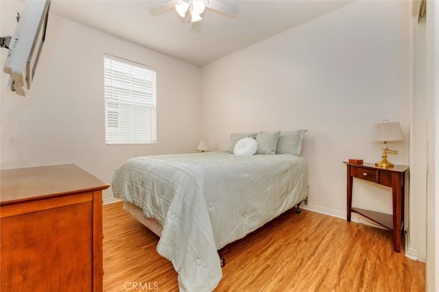 bedroom featuring baseboards, ceiling fan, and light wood-type flooring