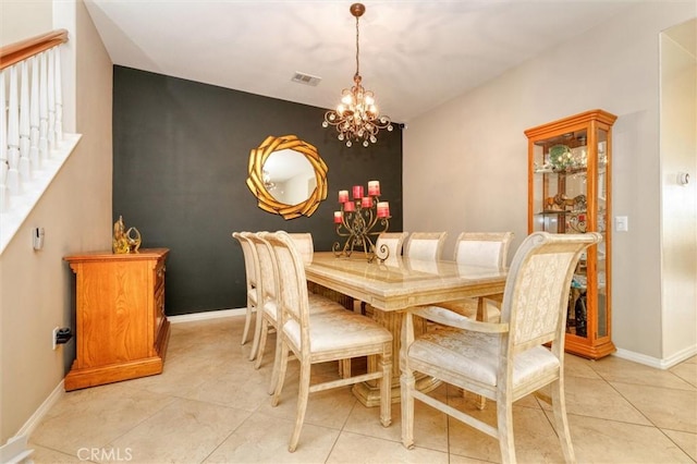 dining area with visible vents, light tile patterned floors, baseboards, a notable chandelier, and an accent wall