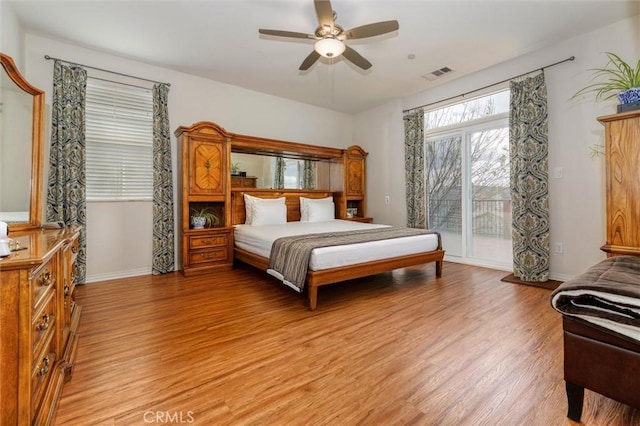 bedroom with a ceiling fan, visible vents, light wood-type flooring, baseboards, and access to outside
