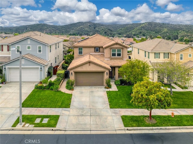 view of front of home with concrete driveway, a mountain view, a residential view, and a tile roof