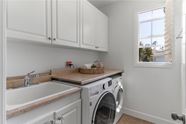 laundry room featuring cabinet space, independent washer and dryer, baseboards, and a sink