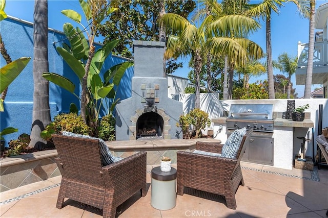 view of patio featuring an outdoor stone fireplace, area for grilling, and an outdoor kitchen