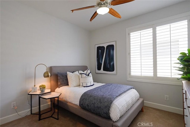 carpeted bedroom featuring baseboards, multiple windows, and ceiling fan