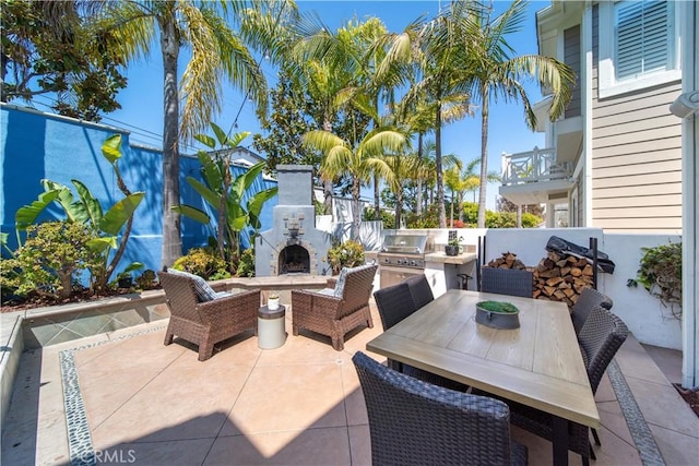 view of patio with an outdoor kitchen, an outdoor living space with a fireplace, and area for grilling