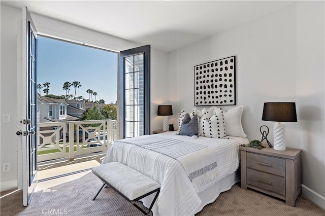 bedroom with carpet floors, baseboards, and access to exterior