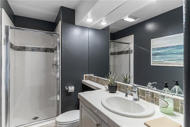 full bathroom with vanity, decorative backsplash, toilet, and a shower stall