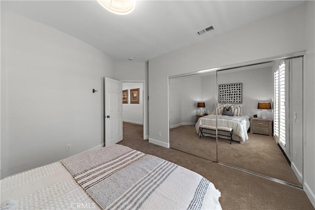 bedroom featuring baseboards, carpet, a closet, and visible vents