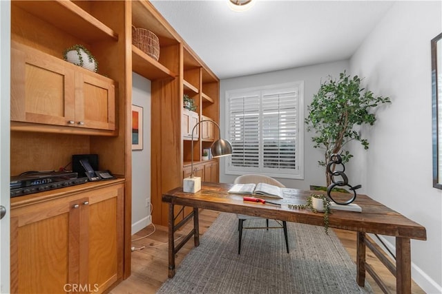 office with light wood-type flooring and baseboards