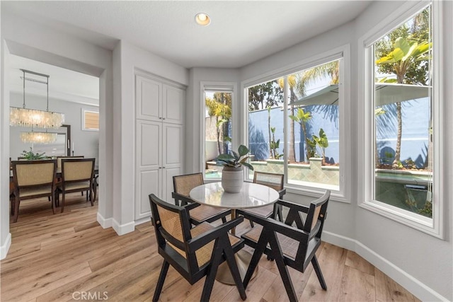 dining space with baseboards, a wealth of natural light, and light wood-style floors