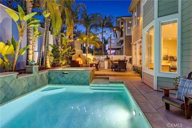 outdoor pool with a patio and an in ground hot tub