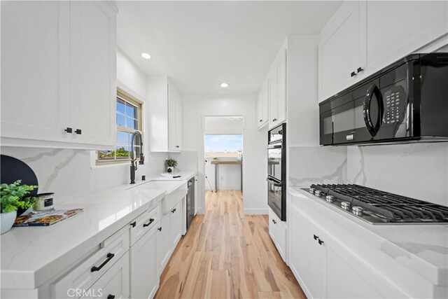 206 Calle De Sirenas, Redondo Beach, CA 90277 - kitchen with appliances with stainless steel finishes, a sink, light wood-style flooring, white cabinets, and decorative backsplash