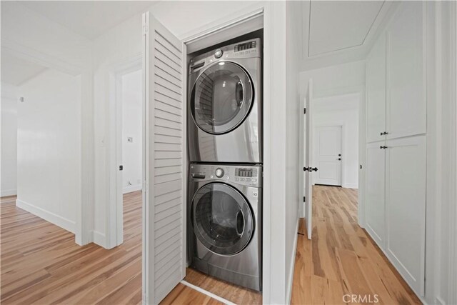 206 Calle De Sirenas, Redondo Beach, CA 90277 - laundry room with stacked washer / drying machine, light wood-type flooring, and baseboards