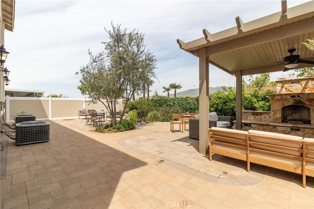 34072 Lily Rd, Yucaipa, CA 92399 - view of patio / terrace with an outdoor living space with a fireplace, outdoor dining space, a ceiling fan, fence, and central AC unit
