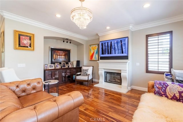 34072 Lily Rd, Yucaipa, CA 92399 - living room featuring ornamental molding, a glass covered fireplace, baseboards, wood finished floors, and a chandelier