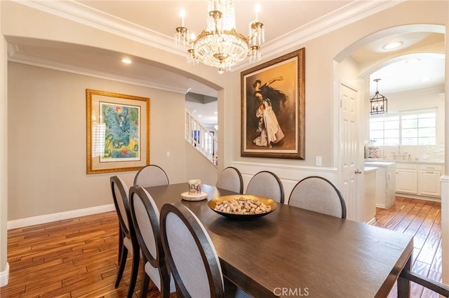 34072 Lily Rd, Yucaipa, CA 92399 - dining space featuring arched walkways, light wood-style flooring, a chandelier, and crown molding