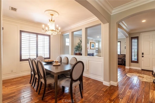 34072 Lily Rd, Yucaipa, CA 92399 - dining space with hardwood / wood-style flooring, a chandelier, arched walkways, crown molding, and baseboards