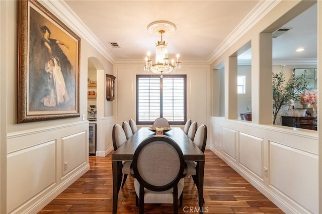 34072 Lily Rd, Yucaipa, CA 92399 - dining space with a decorative wall, ornamental molding, arched walkways, a chandelier, and wood finished floors