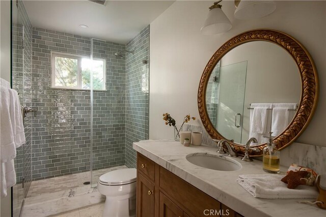 bathroom featuring vanity, toilet, and a shower stall