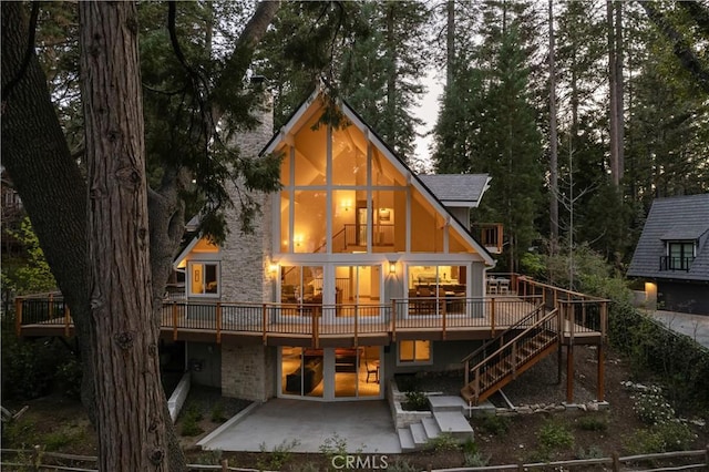 rear view of house featuring a patio, stairs, and a deck