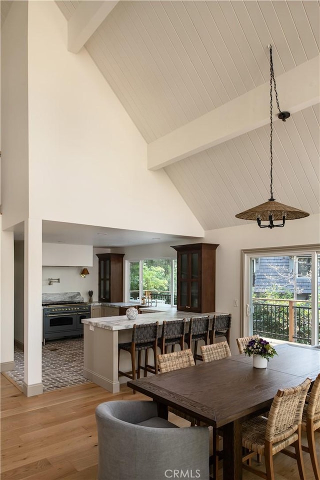 dining room featuring beam ceiling, high vaulted ceiling, baseboards, light wood-type flooring, and wood ceiling